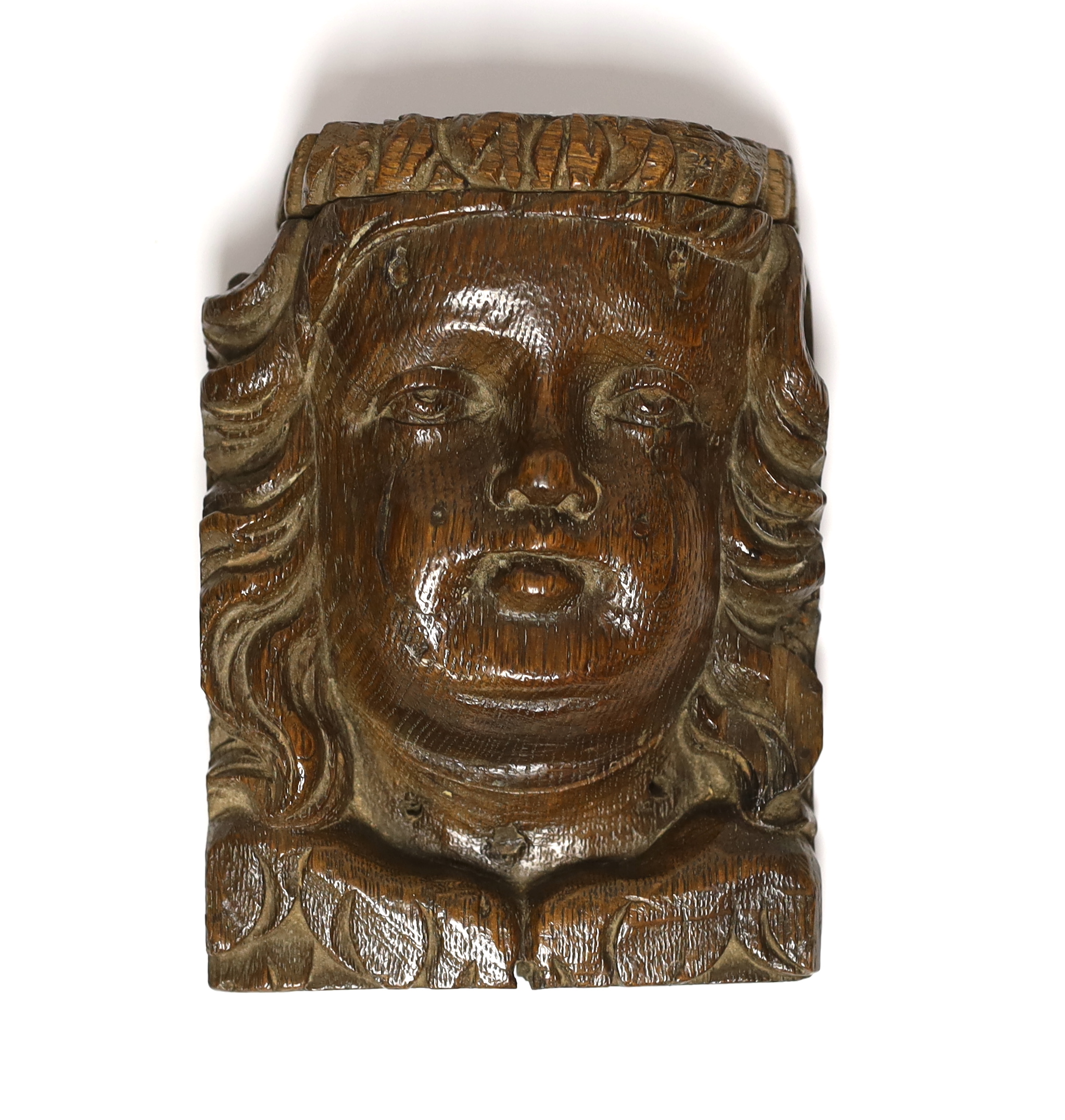 A 17th century carved oak figural terminal, 16cm high